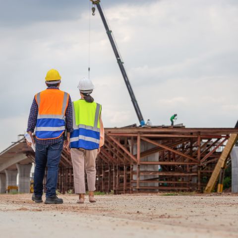 Two workers in hard hats on construction site